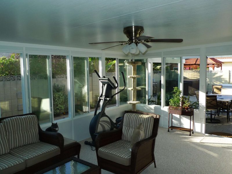 Interior of a Garden Room showing a sliding door, glass windows and furniture in Orange County, CA